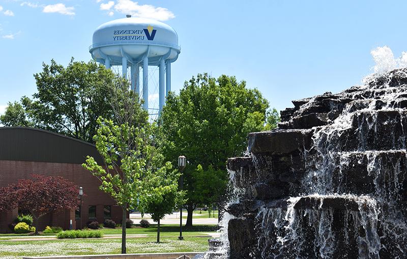 澳门足球博彩官方网址's water tower stands above the trees past the water fountain